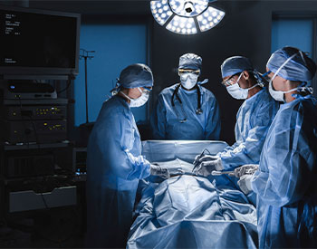 Diverse team of surgeons performing surgery on patient in hospital operating room. Urgent treatment, plastic surgery. Specialists saving patient`s life in operation theater.