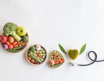 Organic healthy food in wooden bowls,medical stethoscope and green heart shape on white background for the health concept